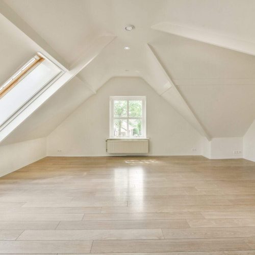 a loft conversion with a wood floor and white walls