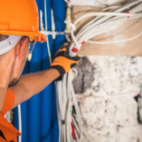Construction Contractor Looking Inside Electrical Installation