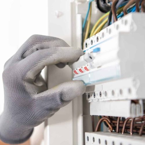 Electrician Testing Fuses In the Electric Box