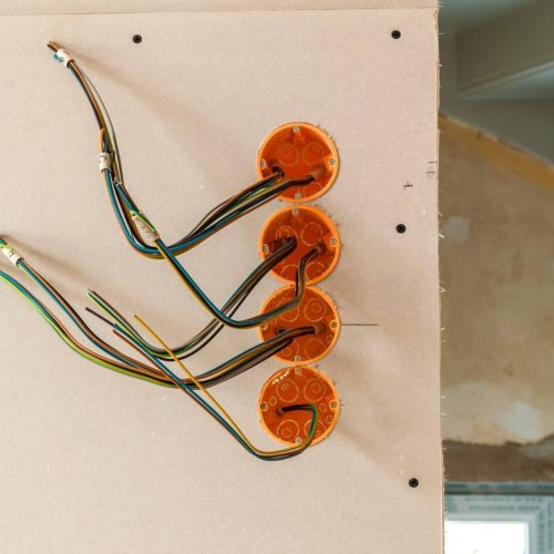 New electrical installation, socket plastic boxes and electrical cables on the wall, renovation