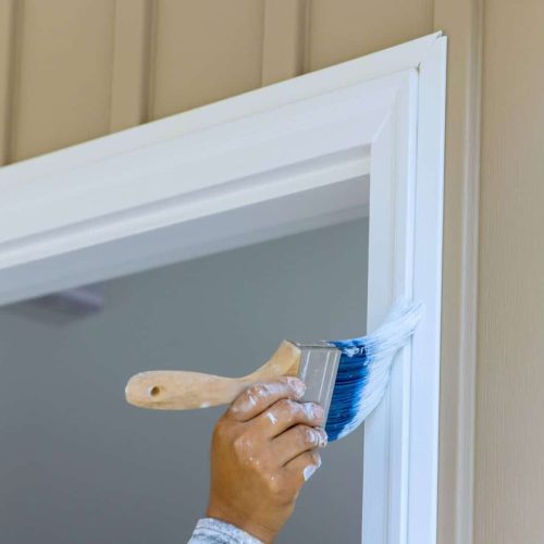 Painter are used paintbrush by to a paint wooden moldings on door trims