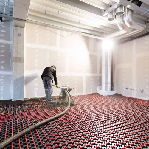 Worker installing floor heating in a new building